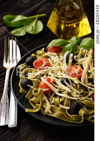 Spinach green pasta with olives, tomatoes, cheese Spinach green pasta with olives, tomatoes, cheese 28285439
