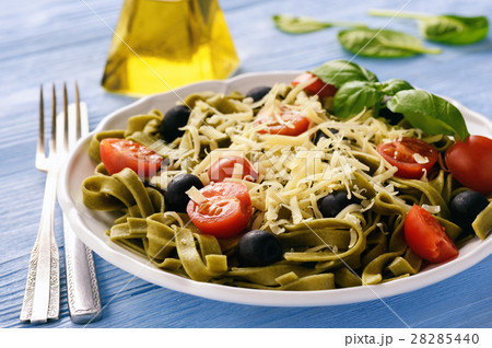 Spinach green pasta with olives, tomatoes, cheese 28285440