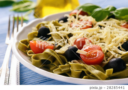 Spinach green pasta with olives, tomatoes, cheese 28285441