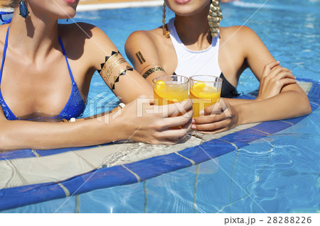 Women drinking a cocktails  relaxing by pool 28288226