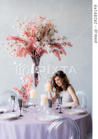 Smiling bride sitting by the table and decorations Smiling bride sitting by the table and decorations 28289149