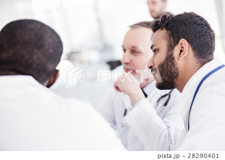 Serene bearded physician hearing colleagues during Serene bearded physician hearing colleagues during 28290401