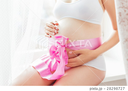 Pregnant woman with pink bow on belly.  28298727