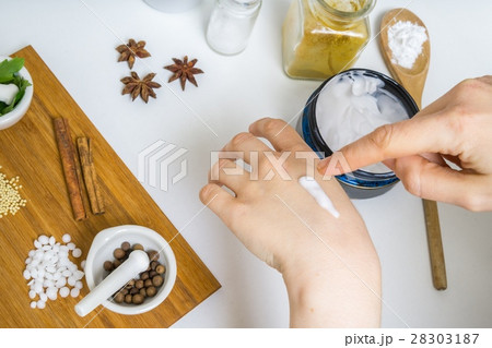 Young woman is applying homemade cream on her skin 28303187