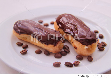 Chocolate eclairs on plate on white background 28304609