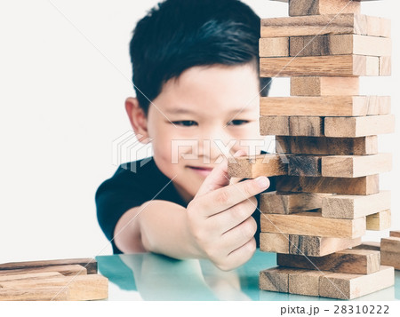 Asian kid is playing wood blocks tower game Asian kid is playing wood blocks tower game 28310222