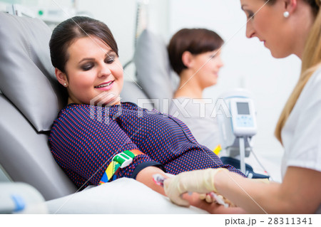 Doctor checking access at female blood giver 28311341