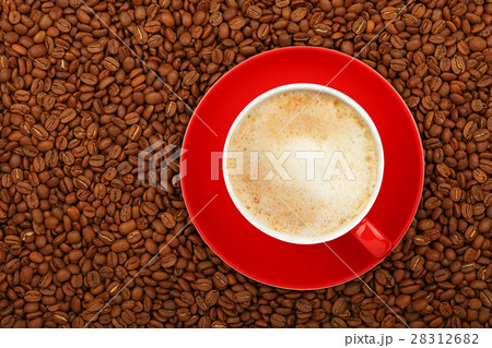 Full latte in red cup with saucer on coffee beans 28312682