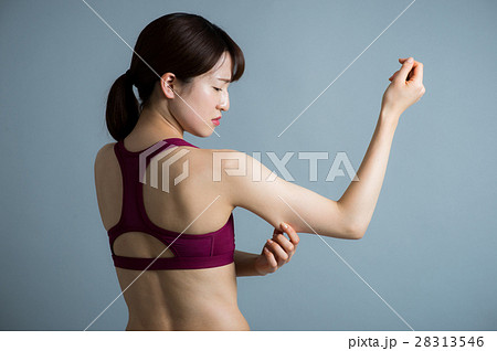 二の腕を気にする若い代女性の写真素材