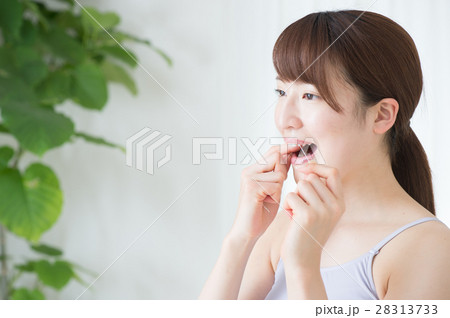 デンタルフロスを使う20代女性 28313733