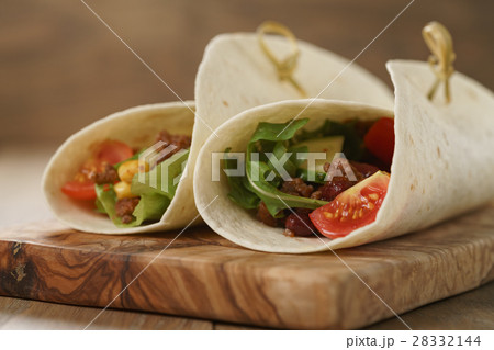 tortilla wrap sandwiches with beef and vegetables on olive board tortilla wrap sandwiches with beef and vegetables on olive board 28332144