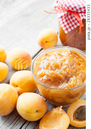 jar of jam and ripe apricot fruits on table 28335433