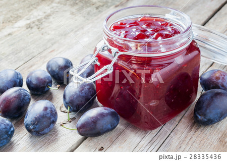plums and jar of jam on table 28335436