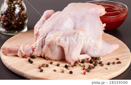 raw chicken carcass with peppercorns on a dark raw chicken carcass with peppercorns on a dark 28339500