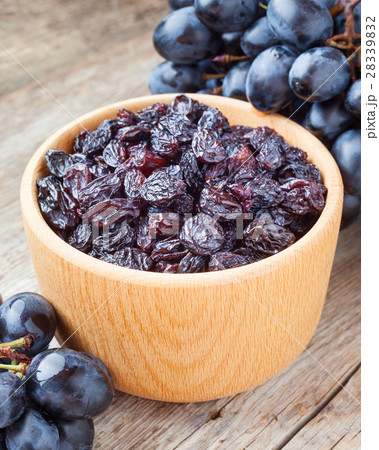 raisins in bowl and grapes on old wooden table raisins in bowl and grapes on old wooden table 28339832