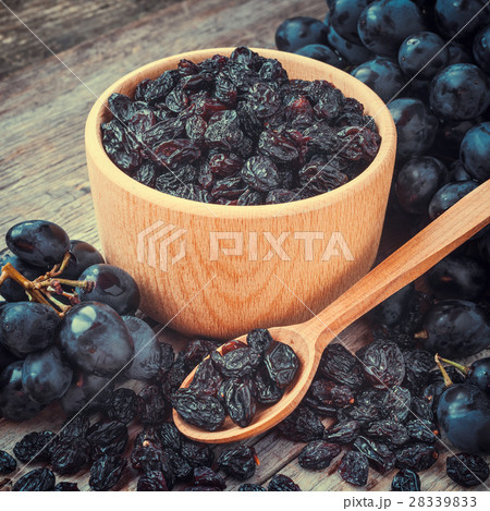 raisins in bowl and blue grapes on table raisins in bowl and blue grapes on table 28339833