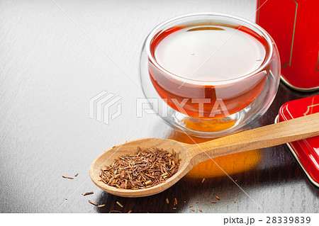 rooibos in spoon closeup, tea cup and tea tin box 28339839