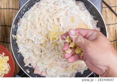 Spaghetti putting mozzarella cheese to the pan Spaghetti putting mozzarella cheese to the pan 28340607