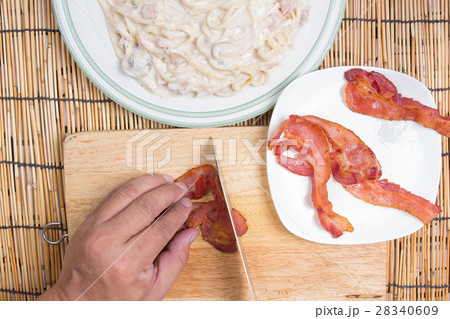 Chef cutting bacon with knife 28340609