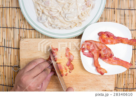 Chef cutting bacon with knife 28340610