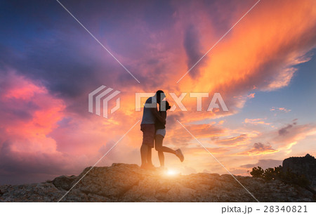 Silhouettes of a hugging and kissing man and woman Silhouettes of a hugging and kissing man and woman 28340821