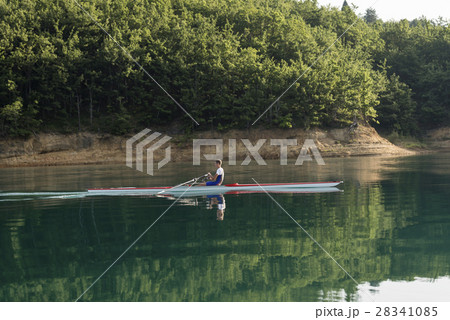 A Young single scull rowing competitor paddles on 28341085
