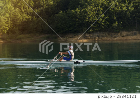 A Young single scull rowing competitor paddles on 28341121