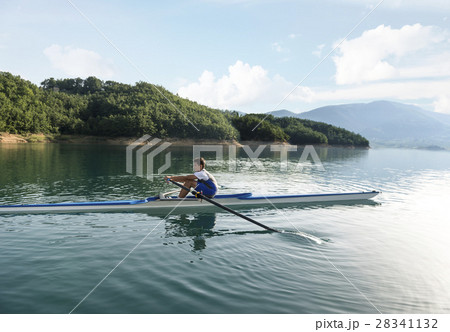 A Young single scull rowing competitor paddles on 28341132
