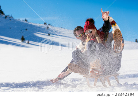 Young Couple Sledding And Enjoying On Sunny Winter Young Couple Sledding And Enjoying On Sunny Winter 28342394