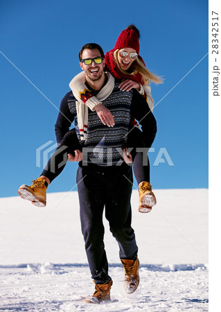 Couple playing in snow. Man giving woman piggyback 28342517