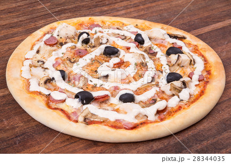 Hot pizza slice with melting cheese on a rustic 28344035