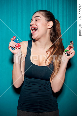Young girl holding poker chips on blue background 28344547