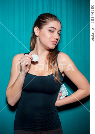 Young girl holding poker chips on blue background 28344580