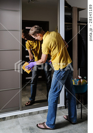 The man cleans the mirror. The man cleans the mirror. 28345189