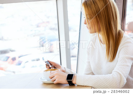 Girl with watch holding mobile phone 28346002