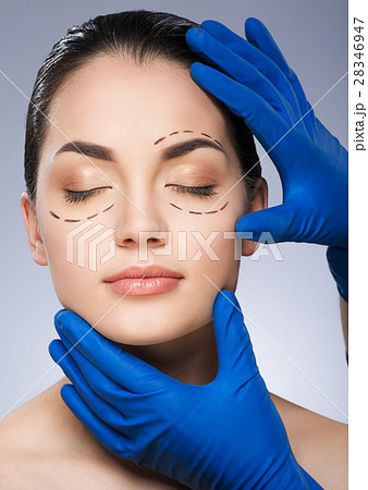 Surgeon holding face of girl with drawn dashed 28346947