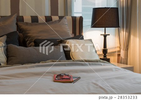 cozy bedroom with books, sunglasses on bed 28353233