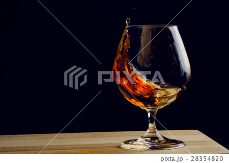 Bohemian glass of cognac on a wooden table 28354820