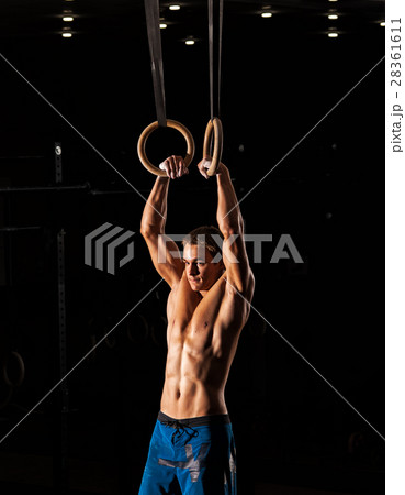 Young sporty man exercising with gymnastics rings 28361611