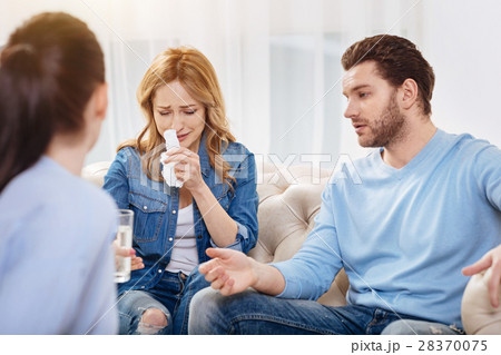 Unhappy sad woman wiping her nose with a tissue Unhappy sad woman wiping her nose with a tissue 28370075