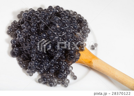 black caviar of halibut in spoon on white plate black caviar of halibut in spoon on white plate 28370122