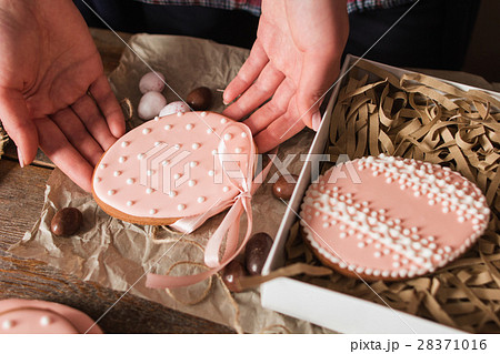Woman packing handmade Easter cookies closeup 28371016