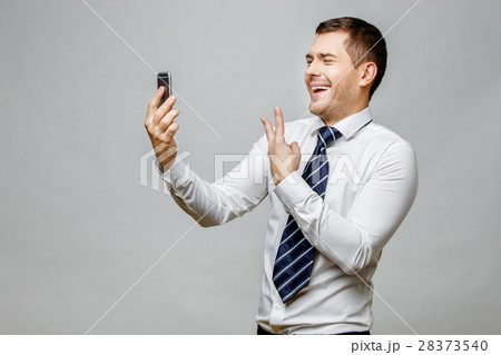 Handsome stylish businessman on grey background 28373540