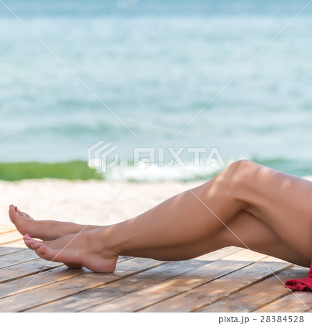 Woman's beautiful legs on the beach Woman's beautiful legs on the beach 28384528