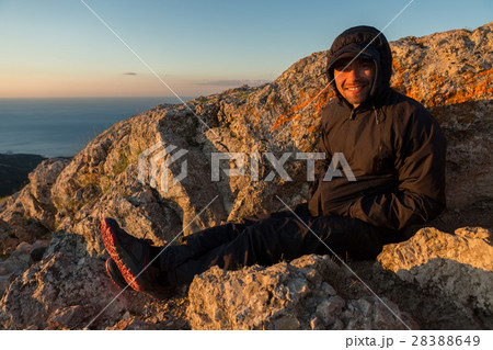Cheerful tourist welcomes sunrise on top of Cheerful tourist welcomes sunrise on top of 28388649