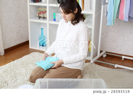 洋服をたたんで収納する女性 28393519