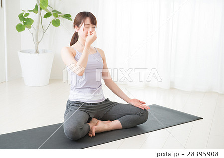 明るい室内でヨガをする若い女性 28395908
