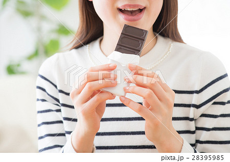 板チョコを食べる若い女性の写真素材