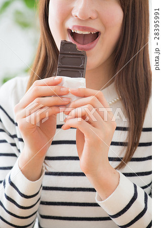 板チョコを食べる若い女性の写真素材