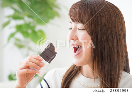 美味しそうに板チョコを食べる代女性の写真素材